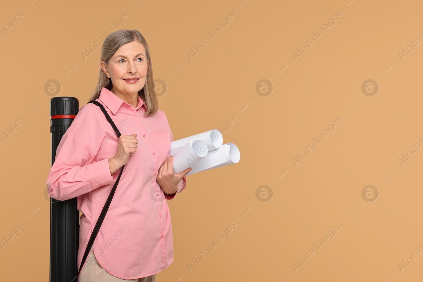 Photo of Architect with drafts and tube on beige background, space for text