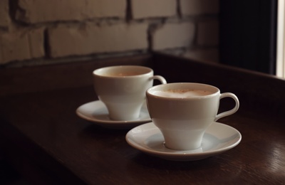 Photo of Cups of fresh aromatic coffee on table