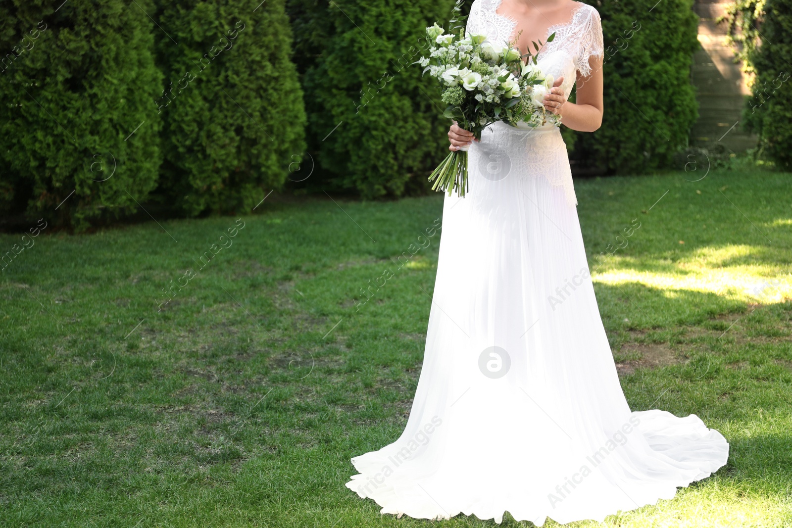 Photo of Bride in beautiful wedding dress with bouquet outdoors, closeup. Space for text