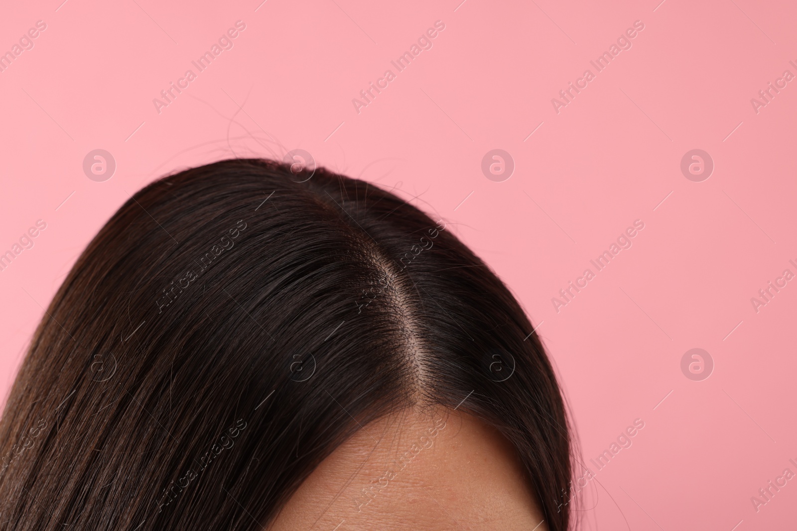 Photo of Woman with healthy hair on pink background, closeup. Space for text