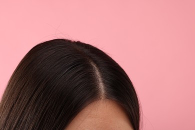 Woman with healthy hair on pink background, closeup. Space for text