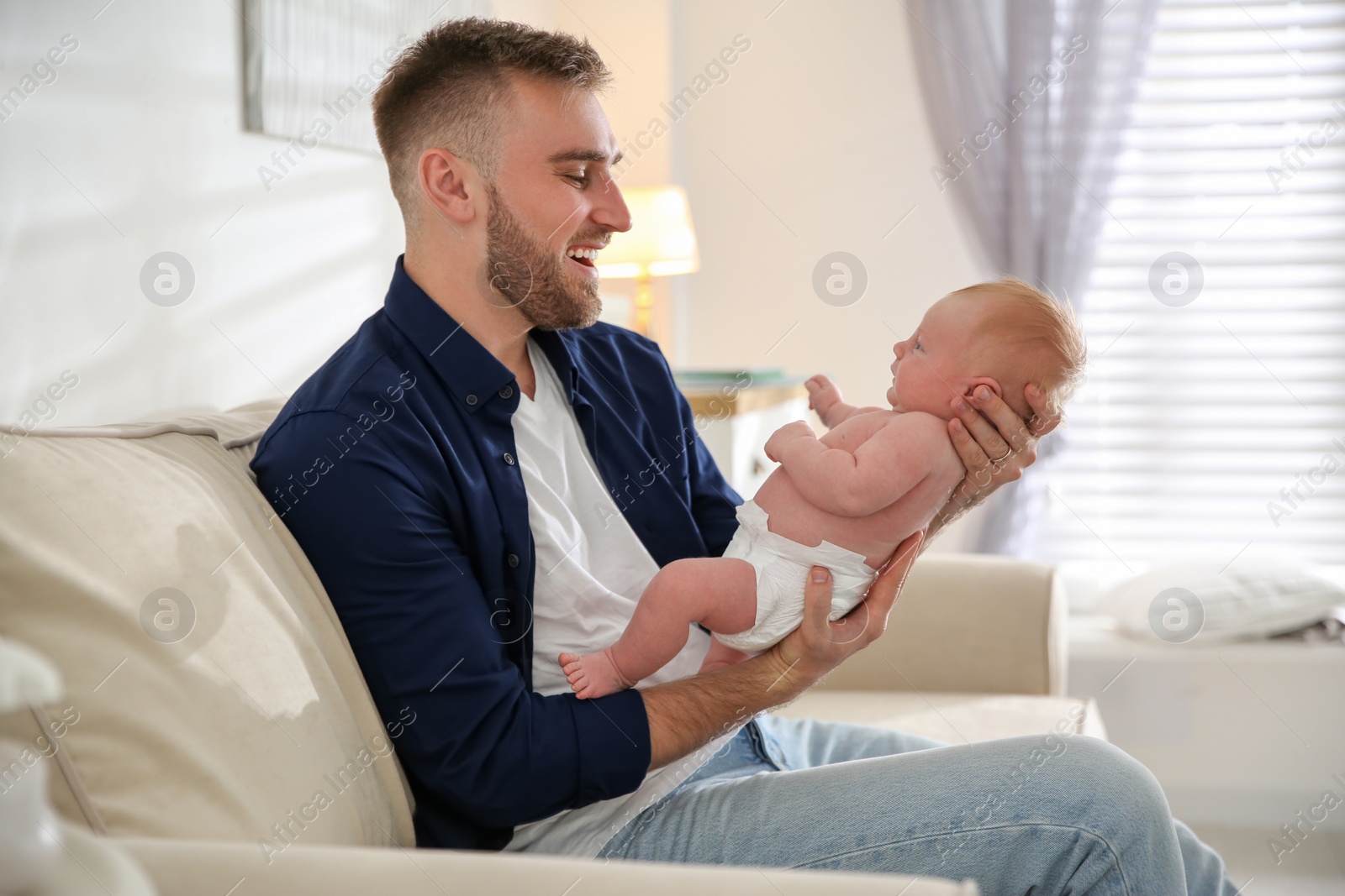 Photo of Father with his newborn son at home