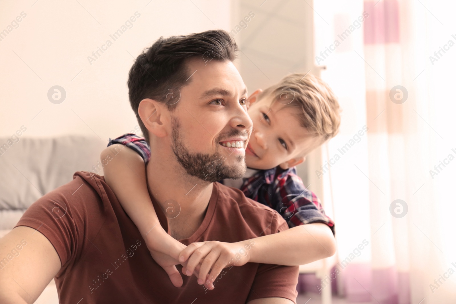 Photo of Little boy and his dad spending time together at home