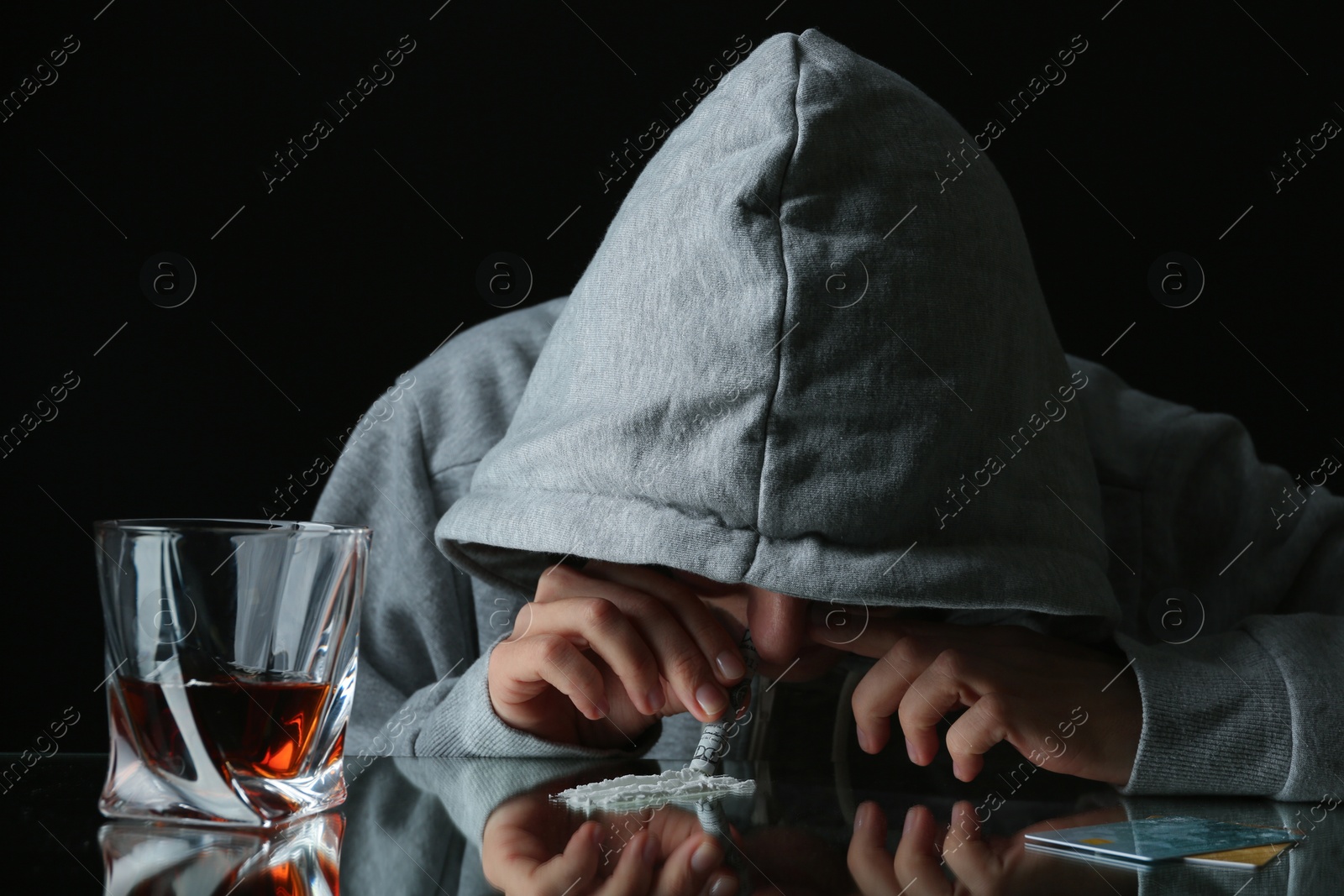 Photo of Drug addict taking cocaine at table, closeup view