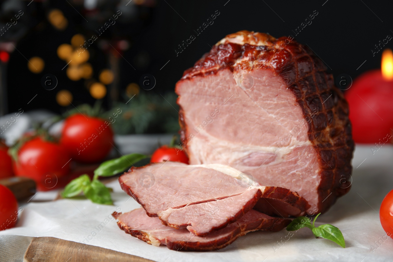 Photo of Delicious ham with tomatoes and basil on parchment, closeup. Christmas dinner