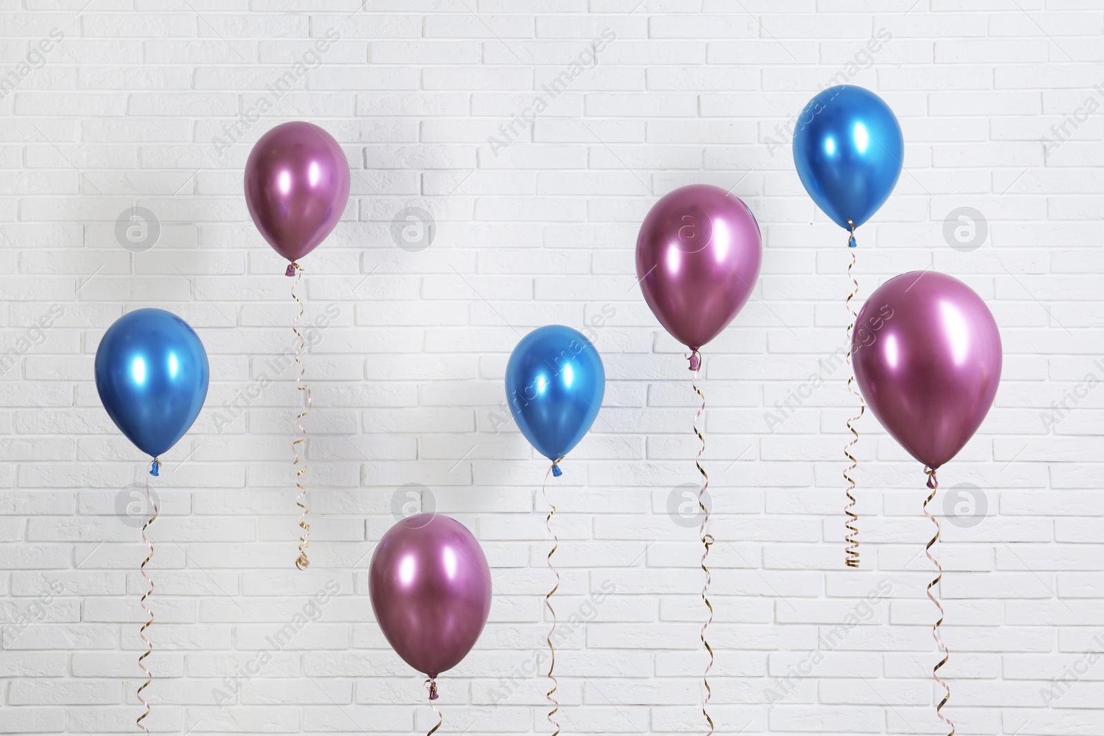 Photo of Bright colorful balloons near brick wall. Party time