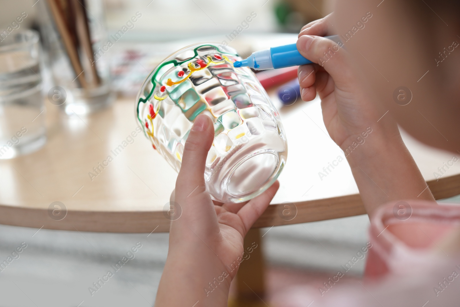 Photo of Little girl painting glass at table indoors, closeup. Creative hobby