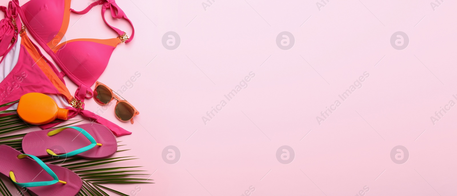 Photo of Beach accessories and space for text on pink background, flat lay. Banner design