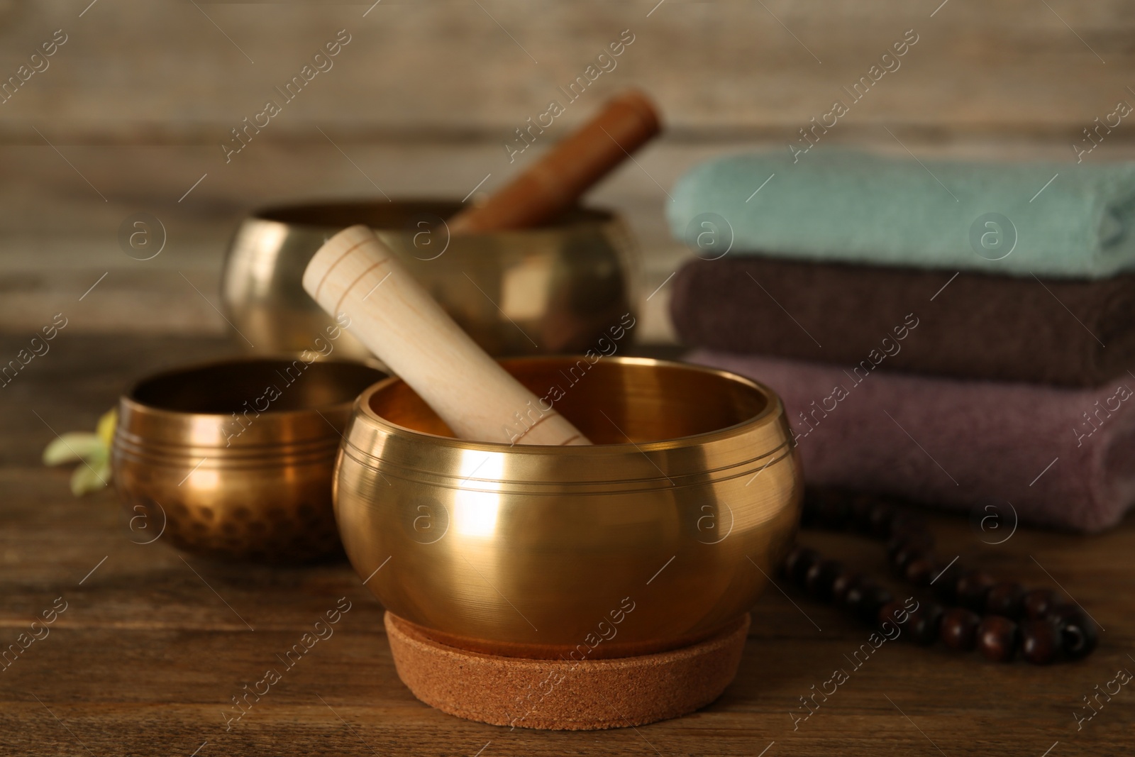 Photo of Composition with golden singing bowls on wooden table