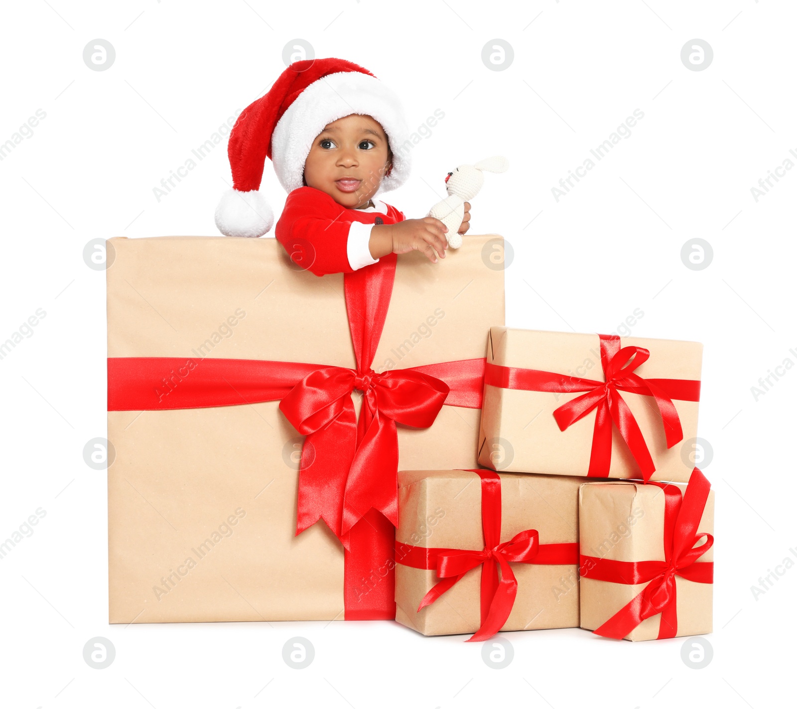 Photo of Festively dressed African-American baby with Christmas gifts and toy on white background