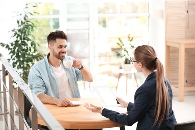 Photo of Female insurance agent working with client in office