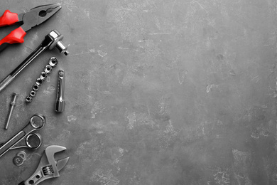 Auto mechanic's tools on grey stone table, flat lay. Space for text