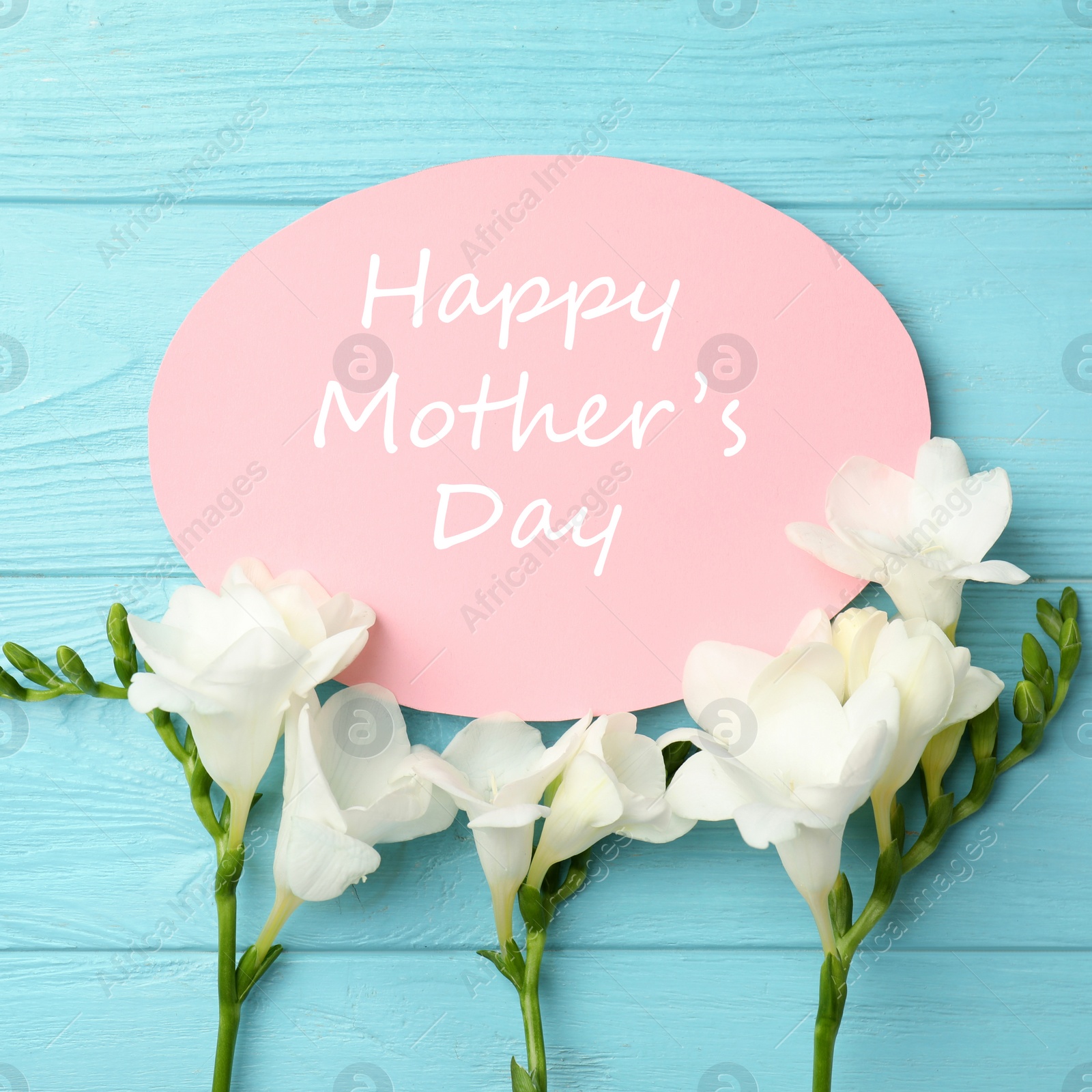 Image of Card with phrase HAPPY MOTHER'S DAY and beautiful flowers on light blue wooden background, flat lay