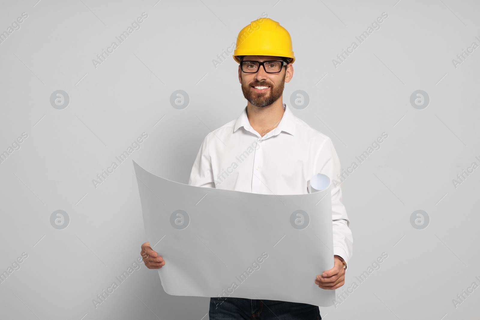 Photo of Professional engineer in hard hat with draft on white background