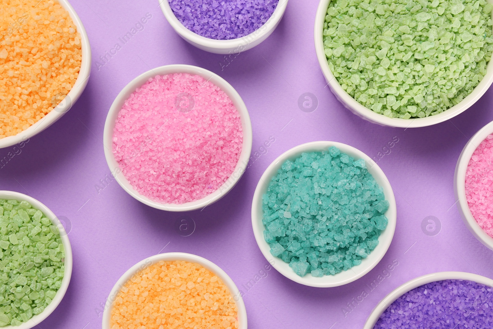 Photo of Different types of aromatic sea salt on purple background, flat lay