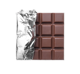 Photo of Delicious milk chocolate bar wrapped in foil isolated on white