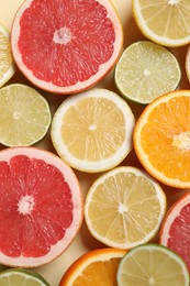 Different cut citrus fruits on beige table, flat lay