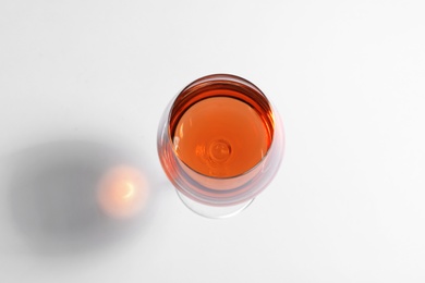 Glass of rose wine on white background, top view