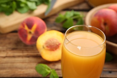 Photo of Natural peach juice and fresh fruits on wooden table, closeup
