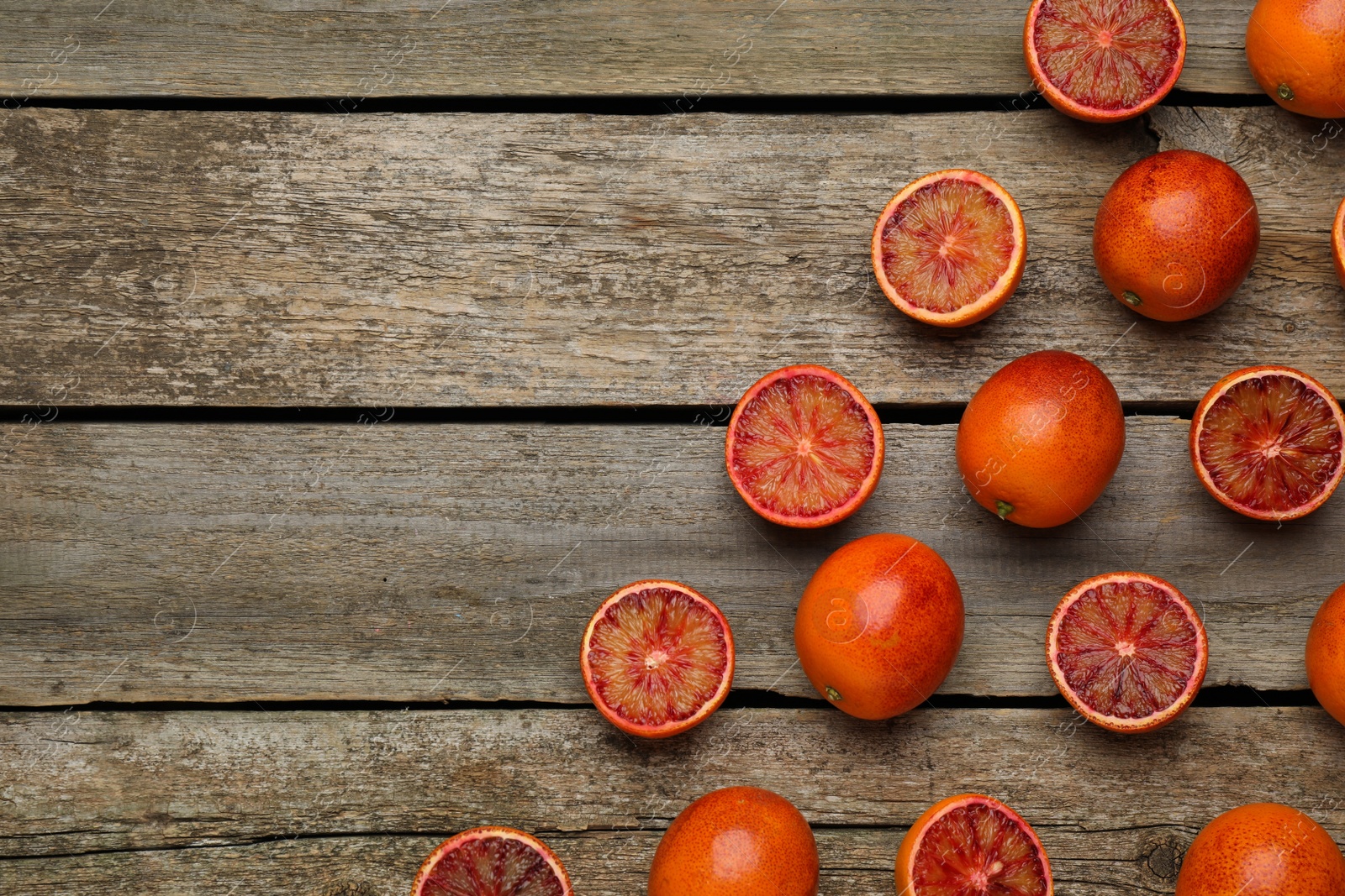 Photo of Many ripe sicilian oranges on wooden table, flat lay. Space for text