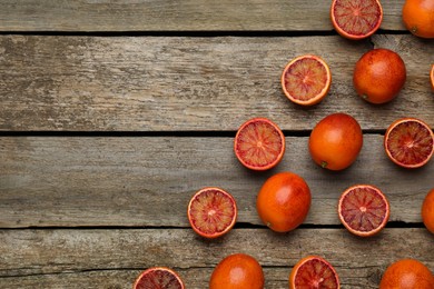 Photo of Many ripe sicilian oranges on wooden table, flat lay. Space for text