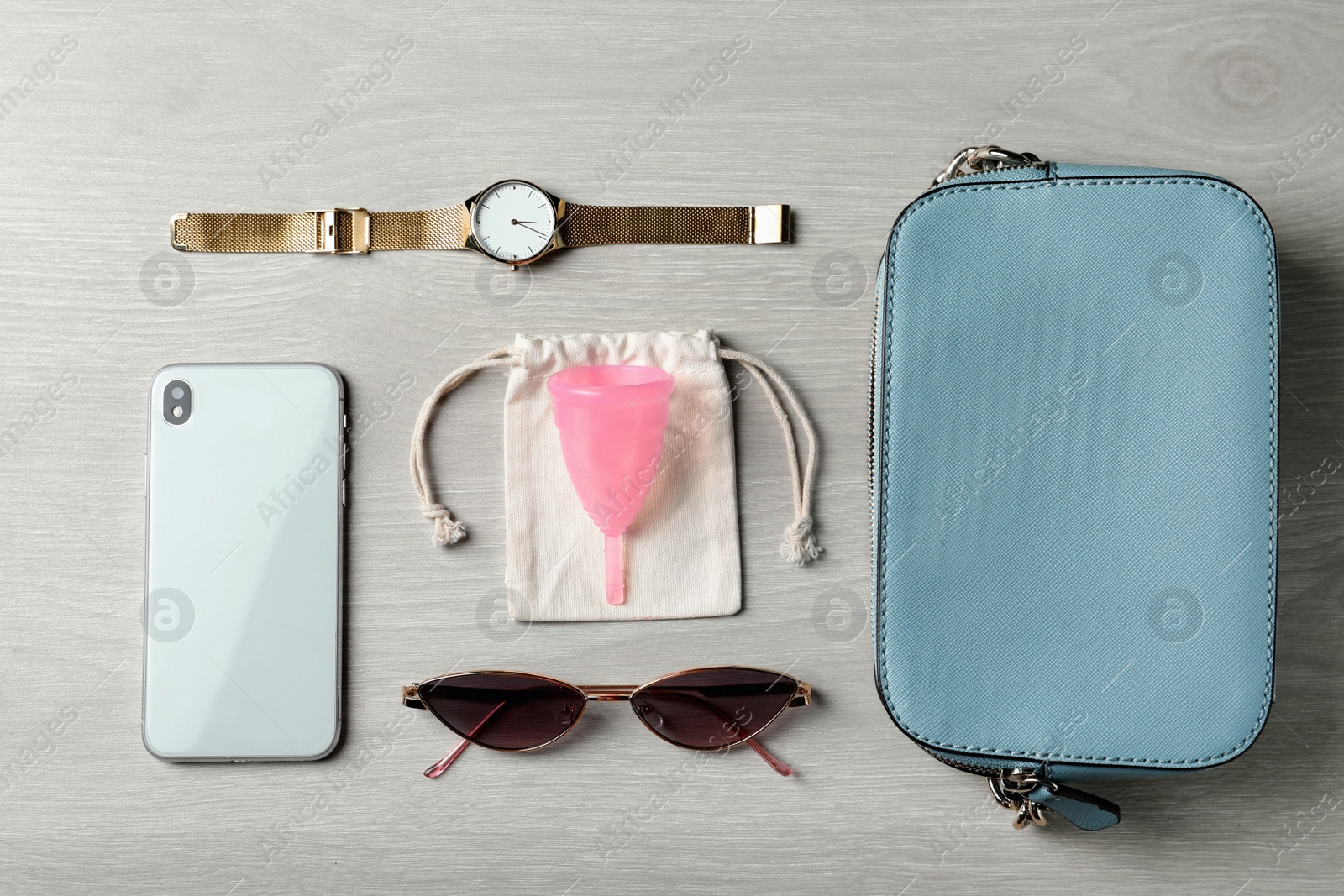 Photo of Flat lay composition with menstrual cup and different women's accessories on white wooden table