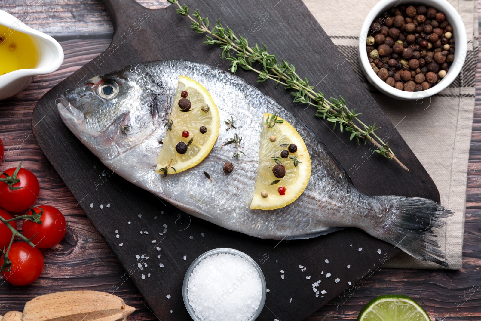 Photo of Fresh dorado fish and ingredients on wooden table, flat lay