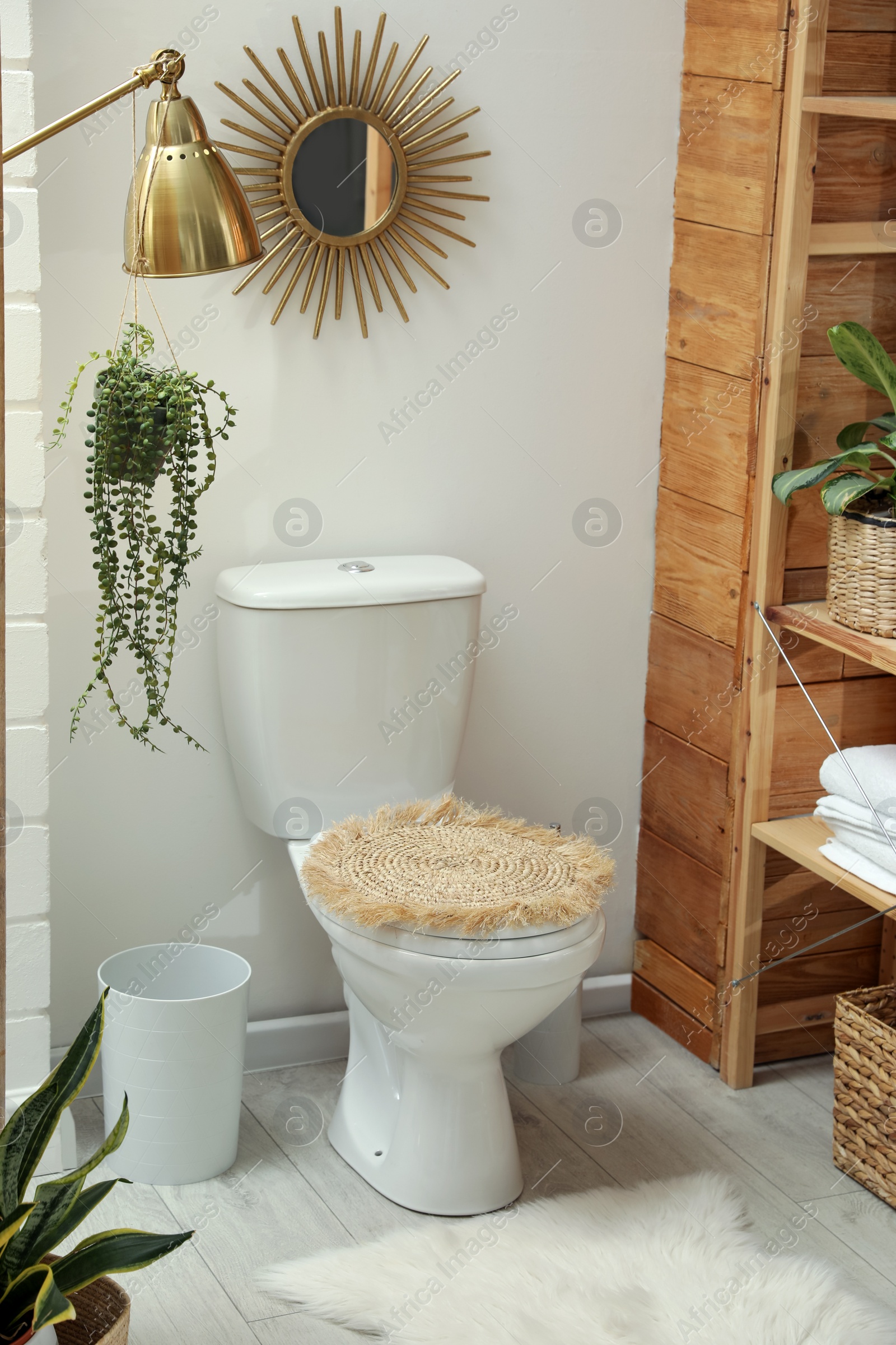 Photo of Toilet bowl and green houseplants in bathroom. Interior design