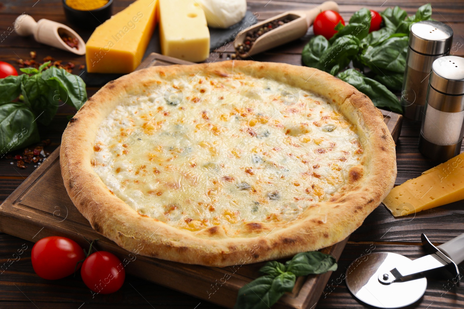 Photo of Delicious cheese pizza and ingredients on wooden table