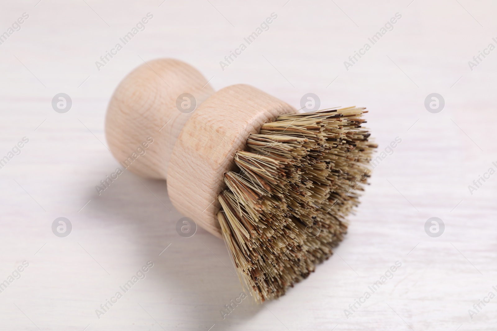 Photo of Cleaning brush on light wooden table, closeup