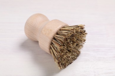 Photo of Cleaning brush on light wooden table, closeup