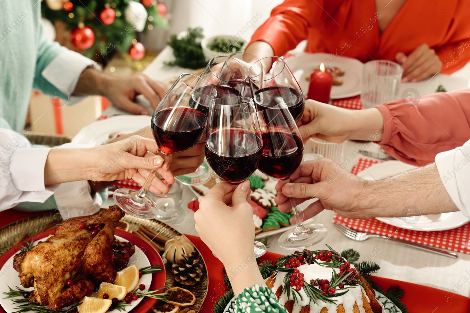 Photo of Family with their friends clinking glasses at festive dinner indoors, closeup. Christmas Eve celebration