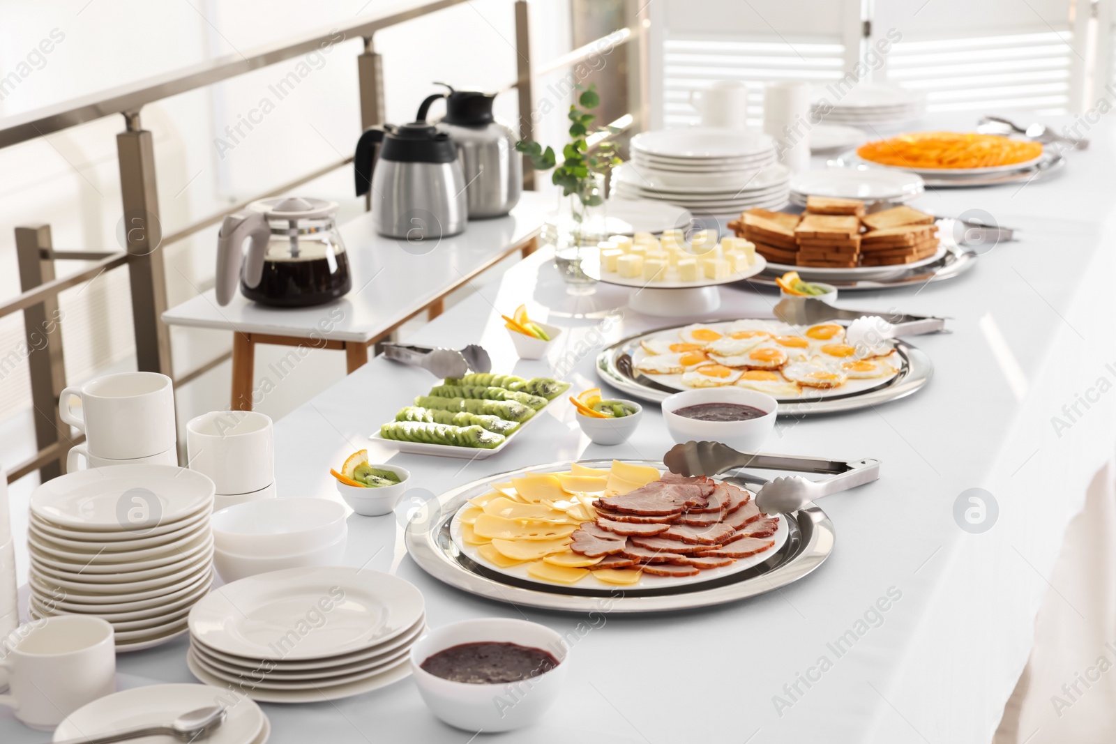 Photo of Clean dishware and different meals for breakfast on white table indoors. Buffet service