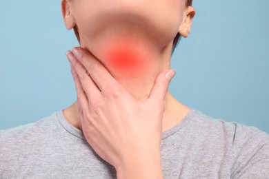 Image of Endocrine system. Woman doing thyroid self examination on light blue background, closeup