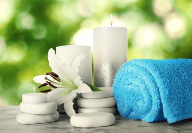 Image of Composition with flower and spa supplies marble on table against blurred green background