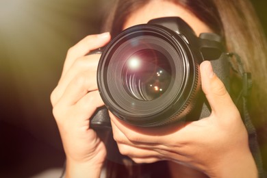 Image of Photographer with professional camera on dark background, closeup