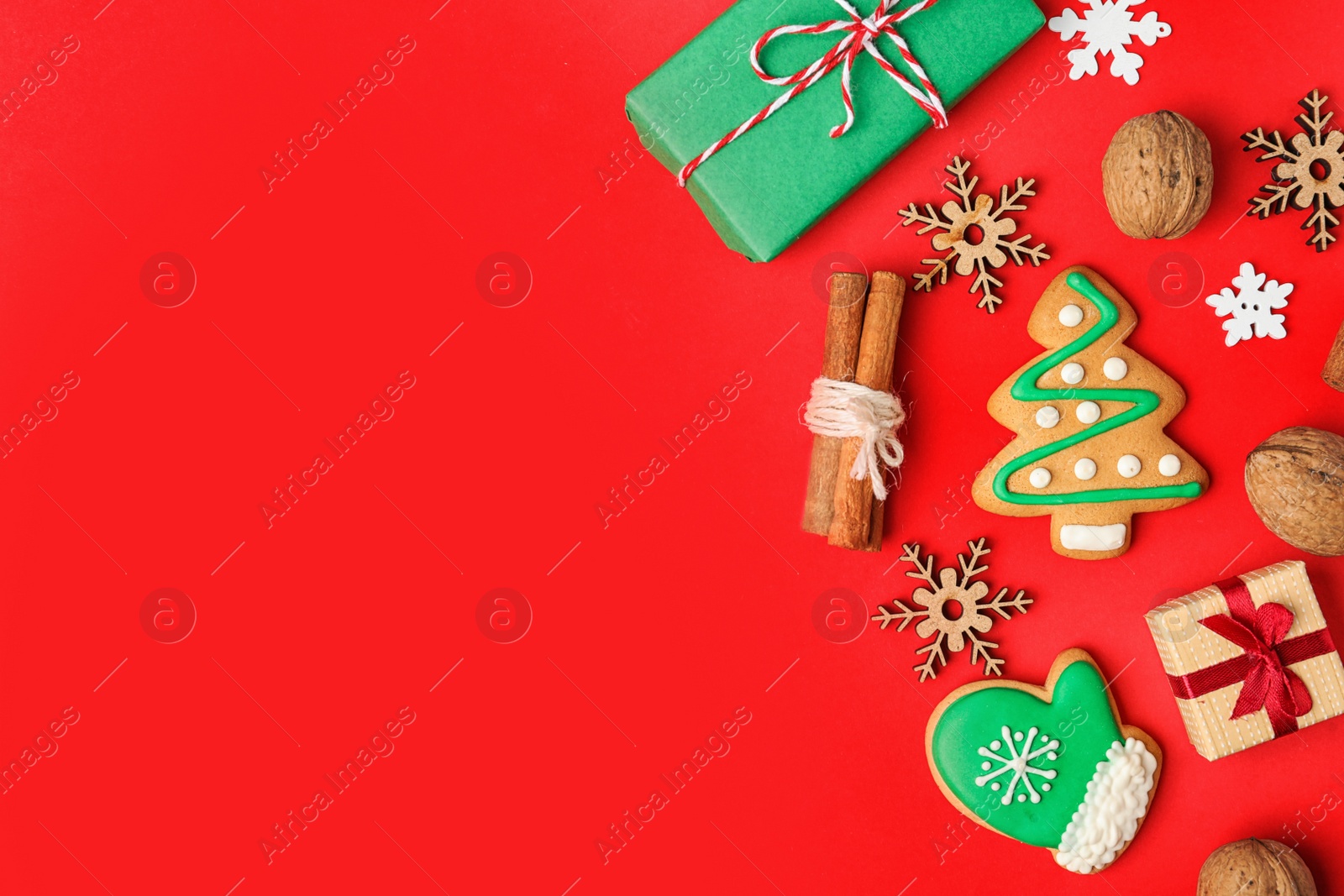 Photo of Flat lay composition with Christmas decorations and treats on red background, space for text. Winter holidays