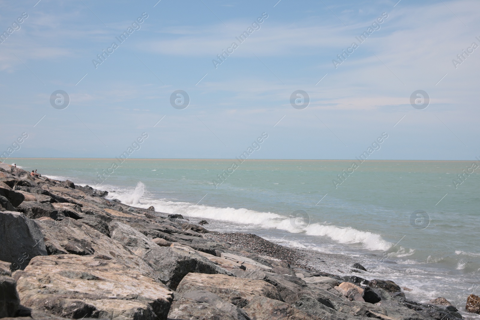 Photo of Picturesque view of foamy waves hitting rocky shore