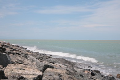 Picturesque view of foamy waves hitting rocky shore