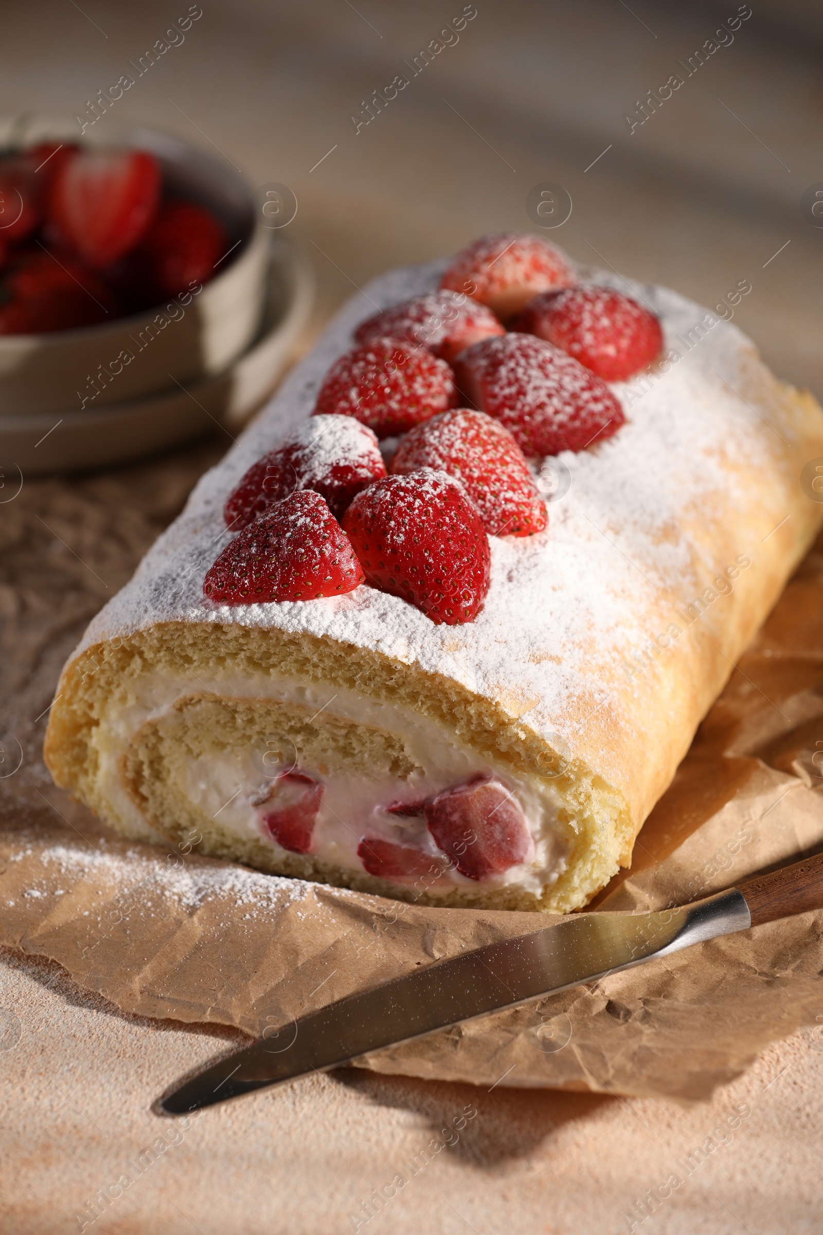 Photo of Delicious cake roll with strawberries and cream on table