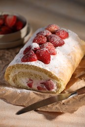 Photo of Delicious cake roll with strawberries and cream on table