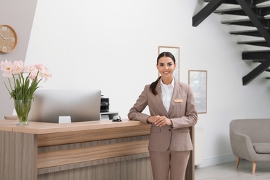 Photo of Portrait of receptionist near desk in modern hotel