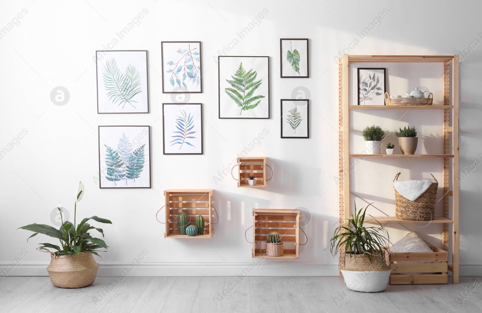 Photo of Beautiful paintings of tropical leaves on white wall in living room interior