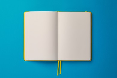 Blank notebook on light blue background, top view