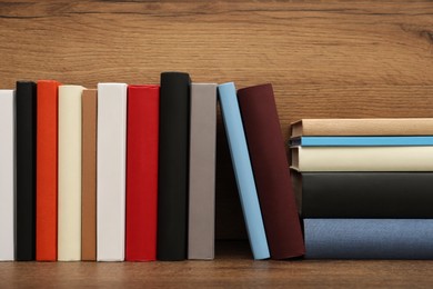 Many different hardcover books on wooden table