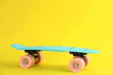 Photo of Turquoise skateboard on yellow background. Space for text