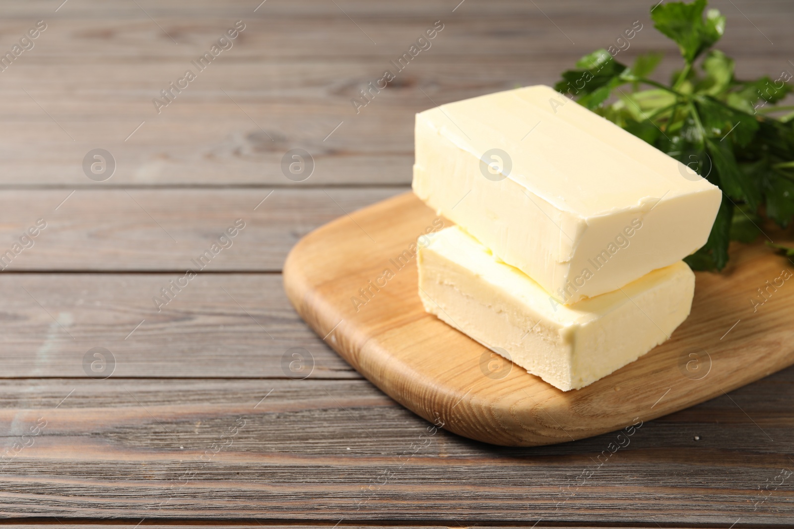 Photo of Tasty butter and parsley on wooden table. Space for text