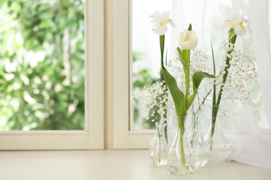 Photo of Beautiful fresh flowers on window sill indoors. Space for text