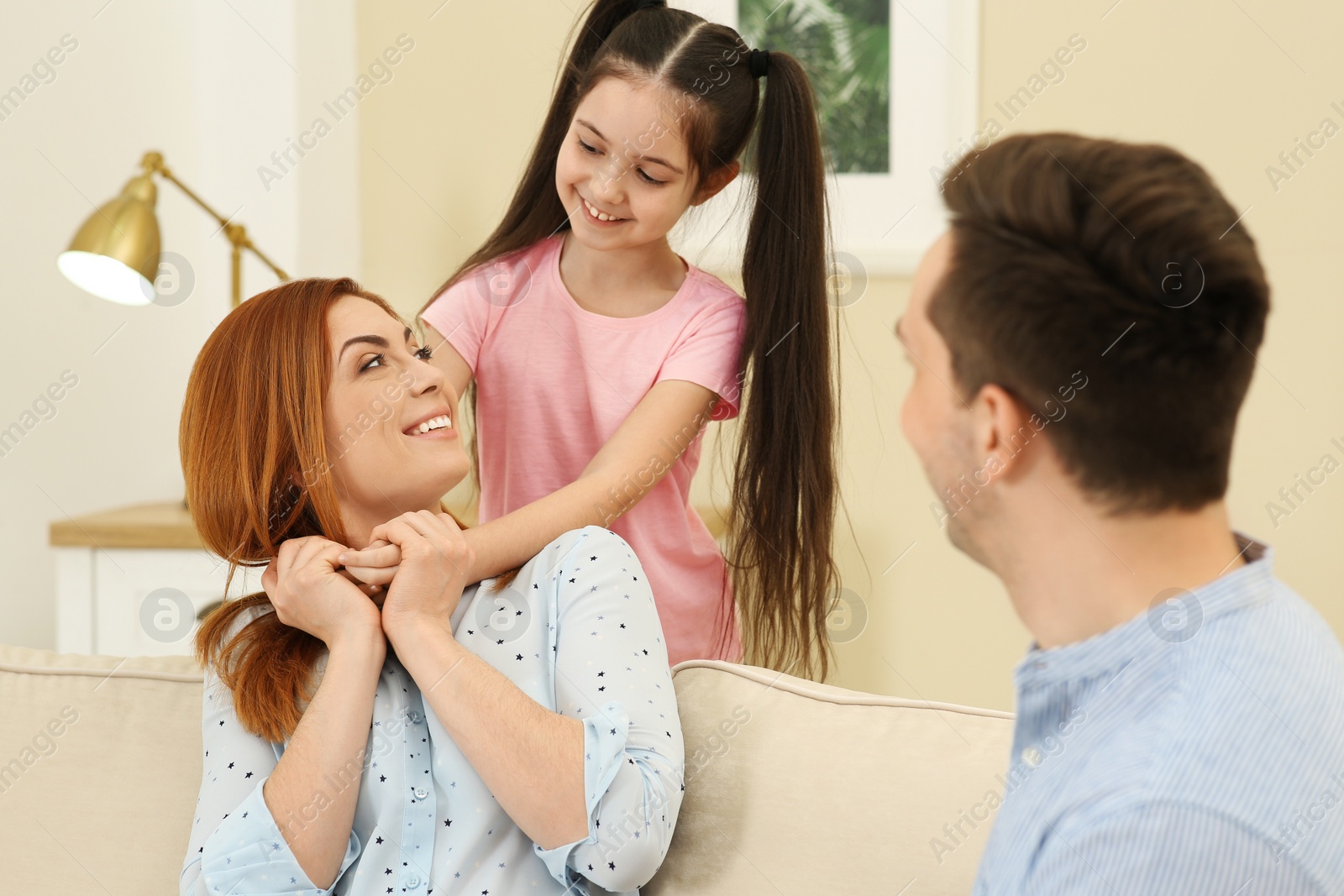 Photo of Little daughter and father congratulating mom at home. Happy Mother's Day