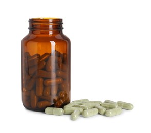 Photo of Bottle and pile of vitamin pills isolated on white